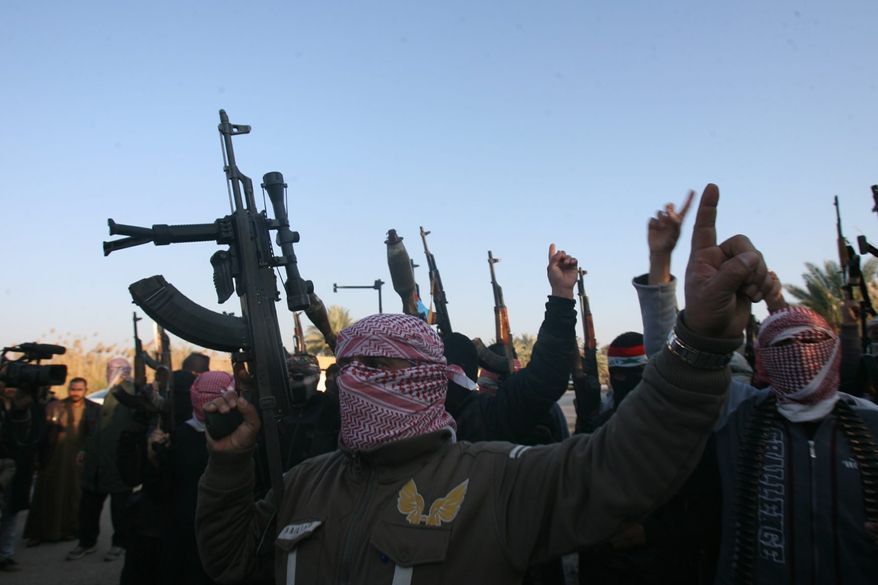 Gunmen gather in a street as they chant slogans against Iraq's Shiite-led government and demanding that the Iraqi army not try to enter Fallujah. U.S. intelligence analysts said al Qaeda's takeover of two Iraqi cities in Anbar province is an outgrowth of a jailbreak orchestrated last summer by the terrorist network. (Associated Press)