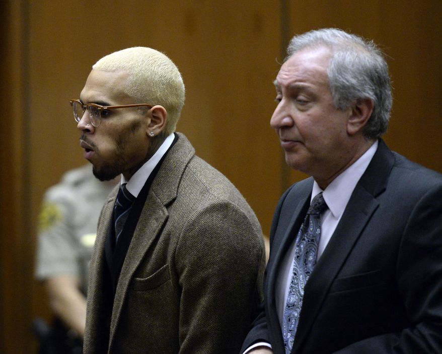 FILE - In this Dec. 16, 2013 file photo, singer Chris Brown, left, appears in court with his attorney Mark Geragos, in Los Angeles. Brown is expected to return to court for a status hearing in a case in which he's accused of hitting a man outside a Washington, D.C., hotel. The R&B singer was arrested in October after a man said the singer hit him outside the W Hotel. Brown and his bodyguard each face a misdemeanor assault charge. (AP Photo/Kevork Djansezian, Pool, File)