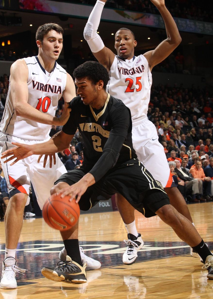 Wake Forest forward Devin Thomas (2) is defended by Virginia's Mike Tobey (10) and forward Akil Mitchell (25) during the first half of an NCAA college basketball game Wednesday, Jan. 8, 2014, in Charlottesville, Va. (AP Photo/Andrew Shurtleff)