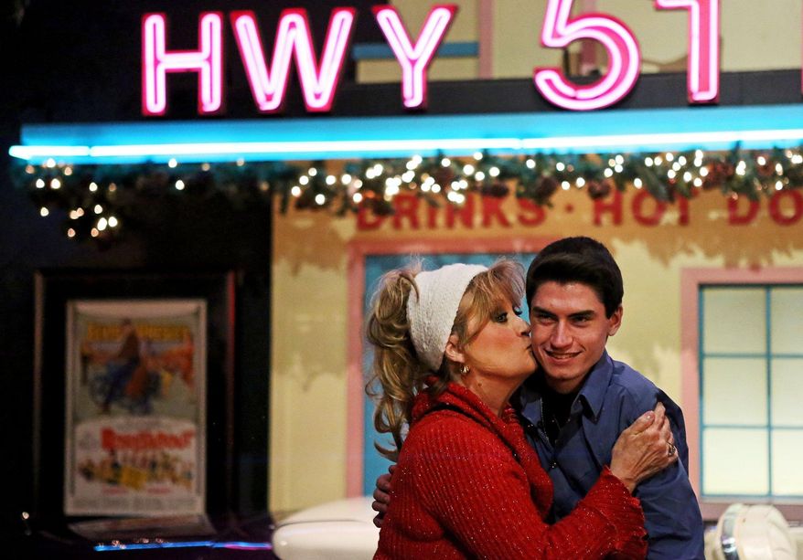 Sandi Boutwell, of Lafayette, La., kisses Canadian singer David Thibault, 16, while he takes a break from performing Elvis Presley songs during an annual birthday celebration for the late singer at the Automobile Museum at Graceland in Memphis, Tenn. Wednesday, Jan. 8, 2014. Presley was born in Tupelo, Miss., on Jan. 8, 1935, and moved to Memphis with his parents at age 13. He was 42 when he died Aug. 16, 1977. (AP Photo/The Commercial Appeal, Yalonda M. James)