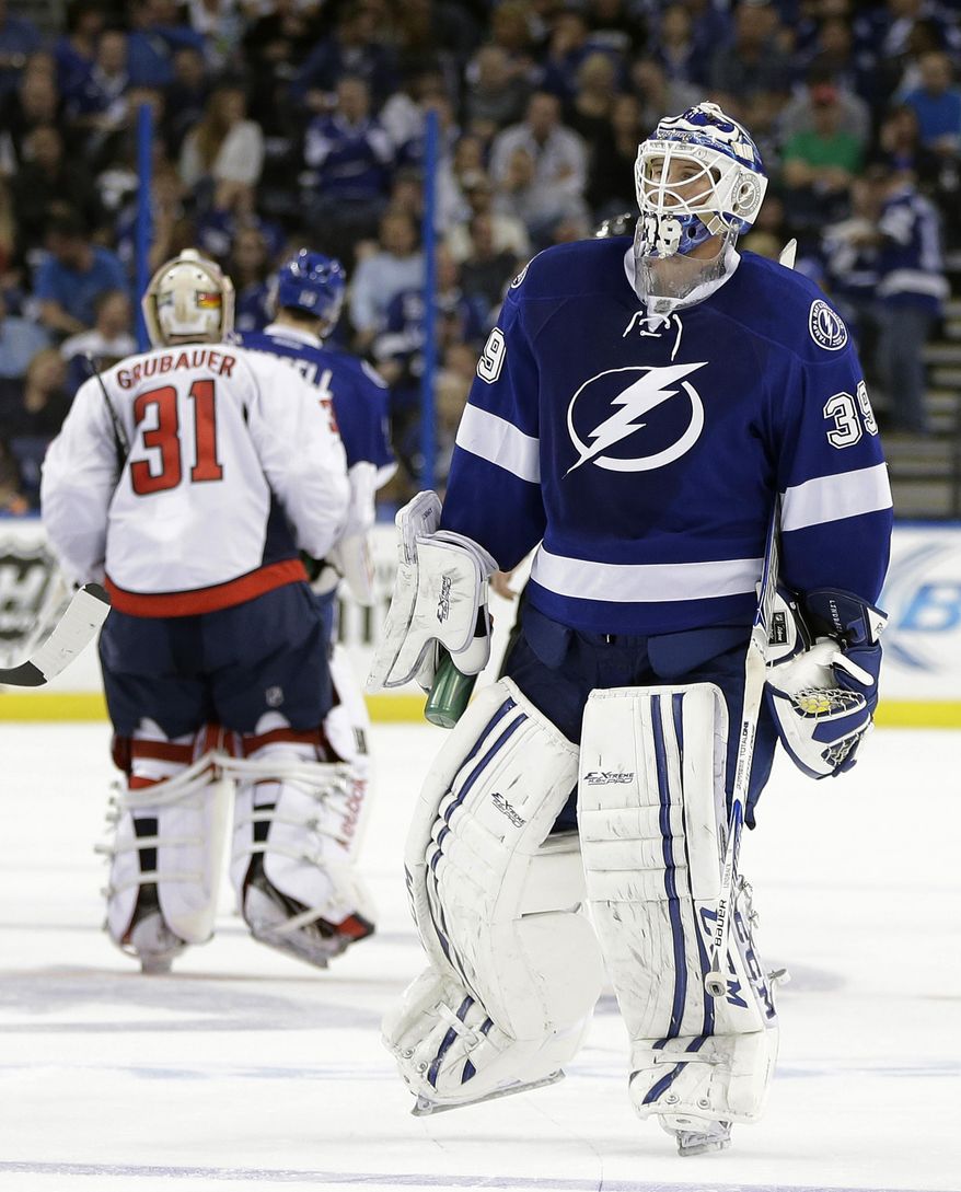 Tampa Bay Lightning goalie Anders Lindback (39), of Sweden, and Washington Capitals goalie Philipp Grubauer (31), of Germany, switch ends of the ice midway through the second period of an NHL hockey game Thursday, Jan. 9, 2014, in Tampa, Fla. The teams changed ends due to poor ice. (AP Photo/Chris O'Meara)