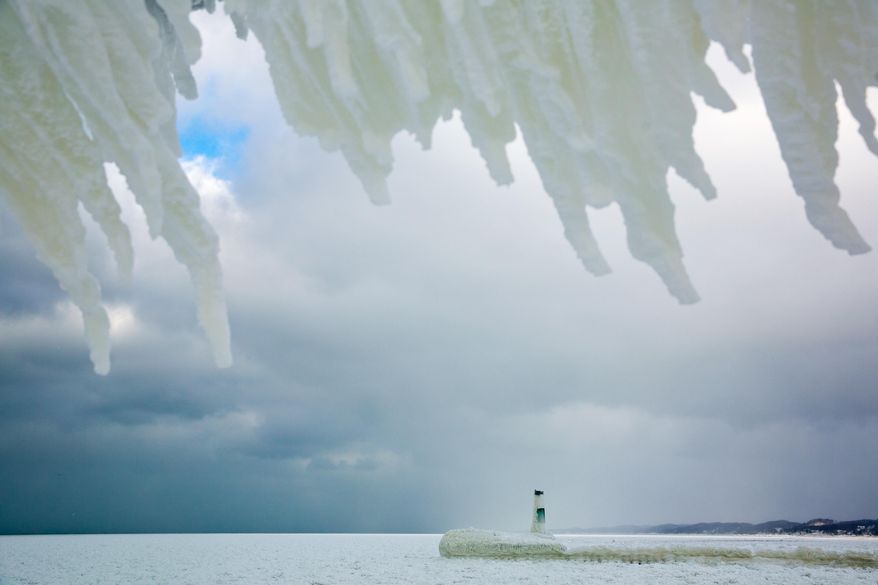 Frozen water hangs off the Grand Haven South Pier and frames the north pier on Wednesday, Jan. 8, 2014 in Grand Haven, Mich. Ice covers the lights along the Grand Haven South Pier on Wednesday, Jan. 8, 2014 in Grand Haven, Mich. Cold weather lingered Thursday in Michigan as many students returned to school for the first time this year, and roads were slippery with freezing rain and snow in the forecast that could cause more problems. (AP Photo/The Muskegon Chronicle, Natalie Kolb) ALL LOCAL TV OUT; LOCAL TV INTERNET OUT