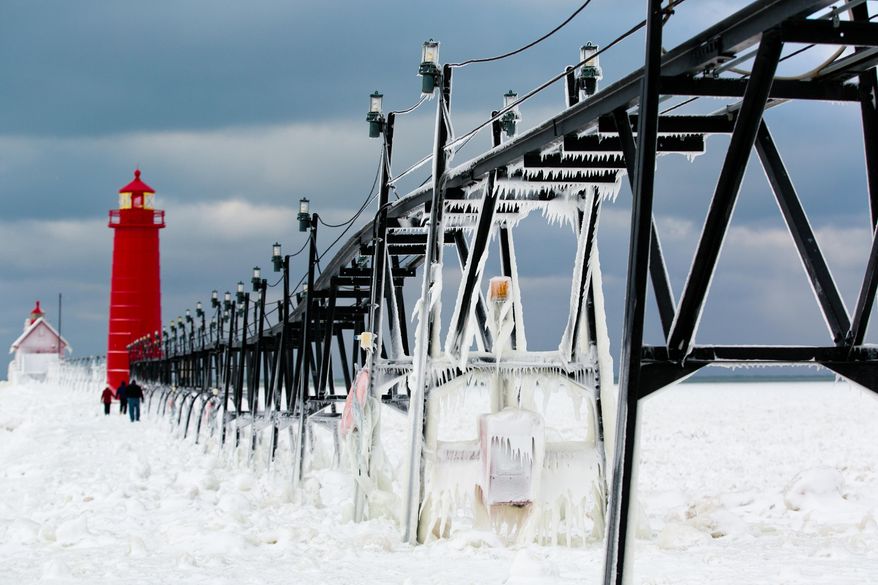 Frozen water clings to the Grand Haven South Pier on Wednesday, Jan. 8, 2014 in Grand Haven, Mich. Cold weather lingered Thursday in Michigan as many students returned to school for the first time this year, and roads were slippery with freezing rain and snow in the forecast that could cause more problems. (AP Photo/The Muskegon Chronicle, Natalie Kolb) ALL LOCAL TV OUT; LOCAL TV INTERNET OUT