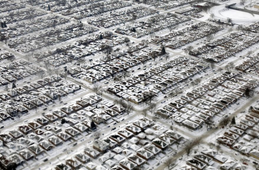 Homes are seen covered in snow and ice Wednesday, Jan. 8, 2014, in Chicago. An arctic blast eased its grip on much of the U.S. on Wednesday, with winds calming and the weather warming slightly a day after temperature records — some more than a century-old — shattered up and down the Eastern Seaboard.(AP Photo/Kiichiro Sato)
