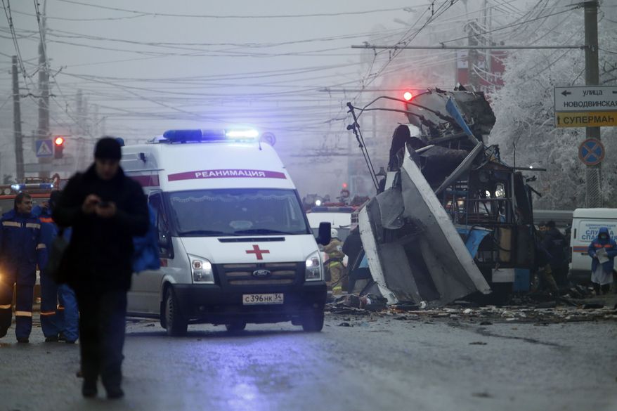 ** FILE ** In this Monday, Dec. 30, 2013, file photo, an ambulance leaves the site of an explosion after a bomb blast tore through the trolleybus, background, in the city of Volgograd. (AP Photo/Denis Tyrin, File)