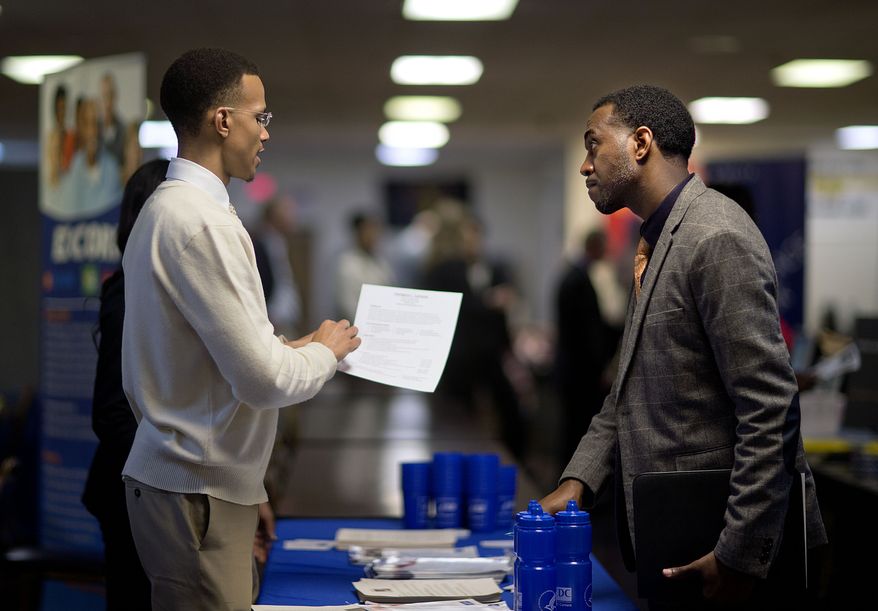 ** FILE ** In this Thursday, Nov. 14, 2013, file photo, retired U.S. Air Force Master Sgt. Thomas Gipson of Atlanta, right, has his resume looked over by Ralph Brown, a management and program analyst with the Centers for Disease Control and Prevention, during a job fair for veterans at the VFW Post 2681, Marietta, Ga. (AP Photo/David Goldman, File)