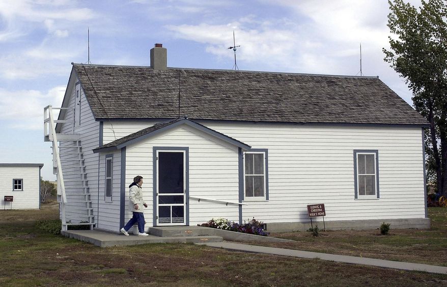 FILE - In this Oct. 10, 2002 file photo Edna Schwab walks toward the front door of the Lawrence Welk farm house in Strasburg, N.D., where Welk taught himself to play accordion. On Friday, Jan. 10, 2014, The state Historical Society is slated to decide whether the state should purchase the bandleader's birthplace. The idea comes two decades after Congress earmarked $500,000 in federal funds to develop a tourist industry in Strasburg. (AP Photo/Will Kincaid, File)