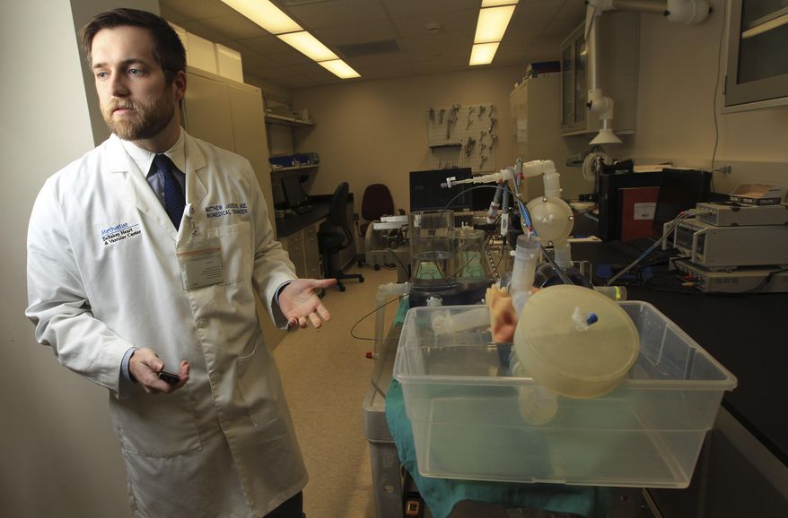 In a Wednesday, Dec. 18, 2013 photo, Matthew Jackson, biomedical engineer, stands next to the heartbeat simulator at Methodist, Wednesday, Dec. 18, 2013, in Houston. (AP Photo/ Houston Chronicle, Karen Warren)