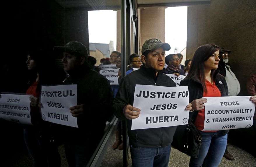 Raziel Huerta, left, and his wife Jamie Huerta stand outside city hall in Durham, N.C., Friday, Jan. 10, 2014 after Durham police released preliminary findings of an internal investigation into the shooting death of Raziel's brother 17-year-old Jesus Huerta on Nov. 19. Police say all their evidence points to the handcuffed teenage suspect shooting himself in the head while in a cruiser despite an officer's pat-down. (AP Photo/Gerry Broome)