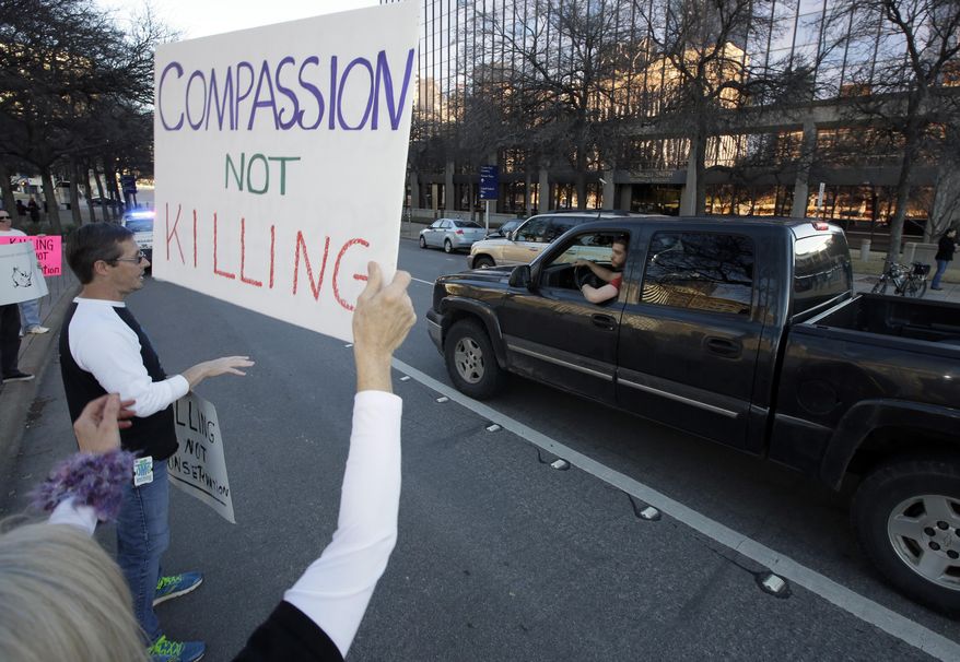 Jim Ries, left, of Atlanta, Ga., stands with nearly 40 other protestors outside the Dallas Convention Center where the Dallas Safari Club is holding its' weekend show and auction, as Reis explains his point and argues his cause with a passerby, Saturday, Jan. 11, 2014, in Dallas. Hunt the black rhino to save the black rhino. That's the Dallas Safari Club's approach to a fundraiser for efforts to protect the endangered species. The group hopes to raise more than $200,000 Saturday by auctioning off the right to shoot and kill a black rhinoceros in the African nation of Namibia. (AP Photo/Tony Gutierrez)