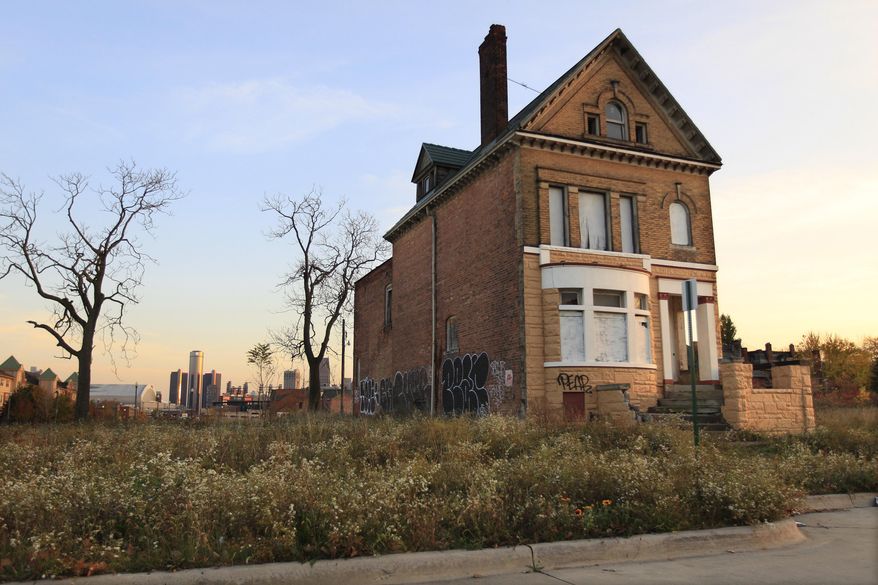 FILE - This Oct. 24, 2013 file photo shows a graffiti-marked abandoned home north of downtown Detroit, in background While Detroit enters 2014 in bankruptcy, facing $18 billion or more in debt, the Motor City's resurgent auto industry is strong enough to host a show that by one estimate will generate nearly $400 million for the area's economy. (AP Photo/Carlos Osorio, File)