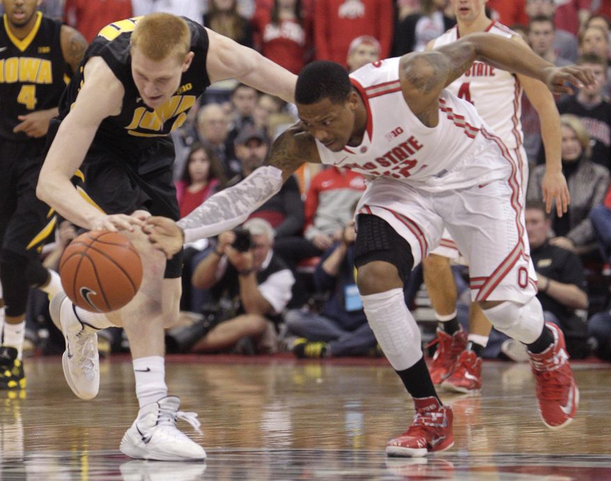 Iowa's Aaron White, left, and Ohio State's Lenzelle Smith chase a loose ball during the second half of an NCAA college basketball game on Sunday, Jan. 12, 2014, in Columbus, Ohio. Iowa won 84-74. (AP Photo/Jay LaPrete)