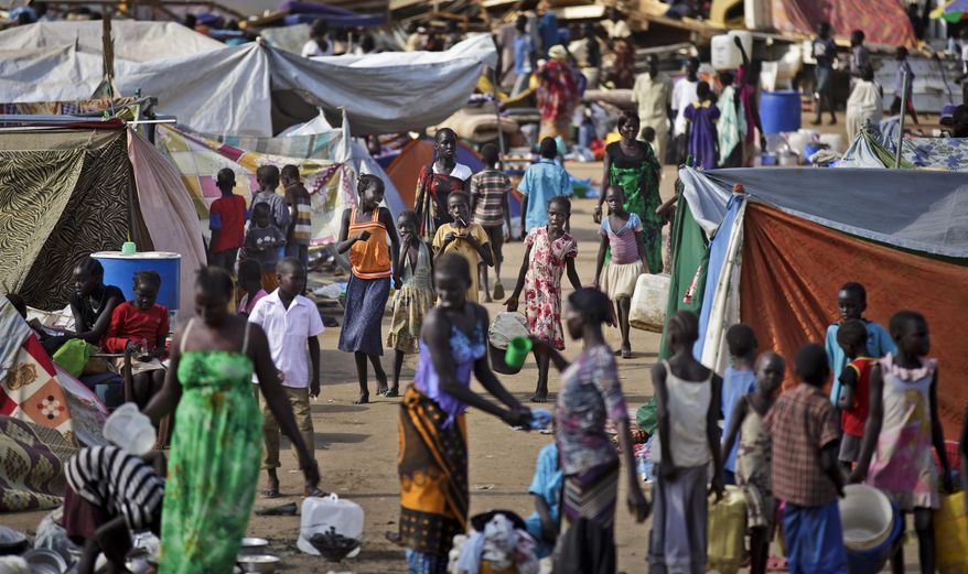 FILE - In this Sunday, Dec. 29, 2013 file photo, displaced people do their daily chores such as bathing, washing clothes, cooking and fetching water at a United Nations compound which has become home to thousands of people displaced by the recent fighting, in the capital Juba, South Sudan. Sub-Saharan Africa has seen a very violent start to 2014 with raging conflicts in South Sudan and Central African Republic - the death tolls are huge and the individual incidents gruesome, with one estimate saying nearly 10,000 have been killed in South Sudan in a month of warfare. (AP Photo/Ben Curtis, File)