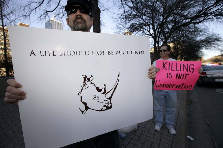 Bob Fretwell of Mesquite, Texas, holds a sign protesting outside the Dallas Convention Center where the Dallas Safari Club is holding it's weekend show and auction, Saturday, Jan. 11, 2014, in Dallas. Hunt the black rhino to save the black rhino. That's the Dallas Safari Club's approach to a fundraiser for efforts to protect the endangered species. The group hopes to raise more than $200,000 Saturday by auctioning off the right to shoot and kill a black rhinoceros in the African nation of Namibia. (AP Photo/Tony Gutierrez)