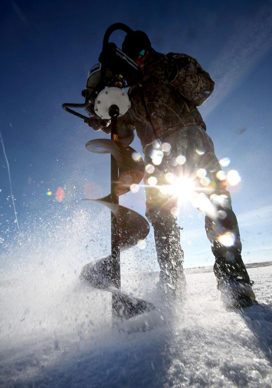 ADVANCE FOR WEEKEND EDITIONS JAN. 11-12 - In this Thursday, Jan. 2, 2014 photo, Stan Massey demonstrates his automatic auger at Magic Reservoir, Idaho. (AP Photo/The Times-News, Ashley Smith) MANDATORY CREDIT