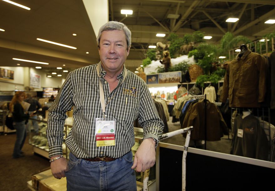 Dallas Safari Club executive director Ben Carter poses for a photo by the club clothing wear booth in the Dallas Exhibit Hall as preparations continue for the clubs weekend show, Wednesday, Jan. 8, 2014, in Dallas. The FBI is investigating death threats made against members of the Dallas Safari Club, which intends to auction off a rare permit to hunt an endangered black rhino, an FBI spokeswoman said Wednesday. (AP Photo/Tony Gutierrez)
