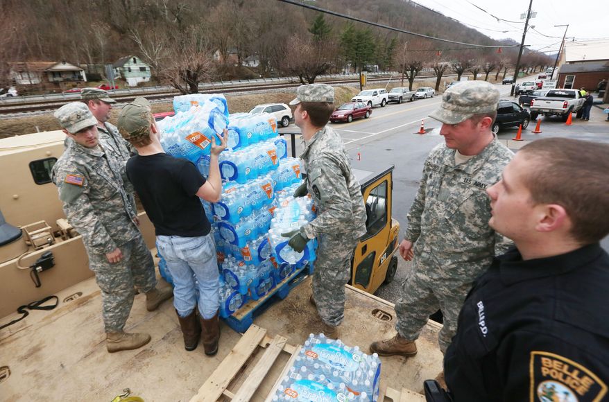 Members of the West Virginia Army National Guard, along with a member of the Belle Police Department and a volunteer, offload emergency water from a military truck to a forklift as citizens line up for water at the Belle Fire Department, Saturday, Jan. 11, 2014, in Belle, W.Va. About 300,000 people Saturday entered their third day of not being able to take showers and wash clothes. Officials remain unclear when it might be safe again. Federal authorities began investigating how the foaming agent escaped the Freedom Industries plant and seeped into the Elk River. Just how much of the chemical leaked into the river was not yet known. (AP Photo/The Daily Mail, Marcus Constantino)