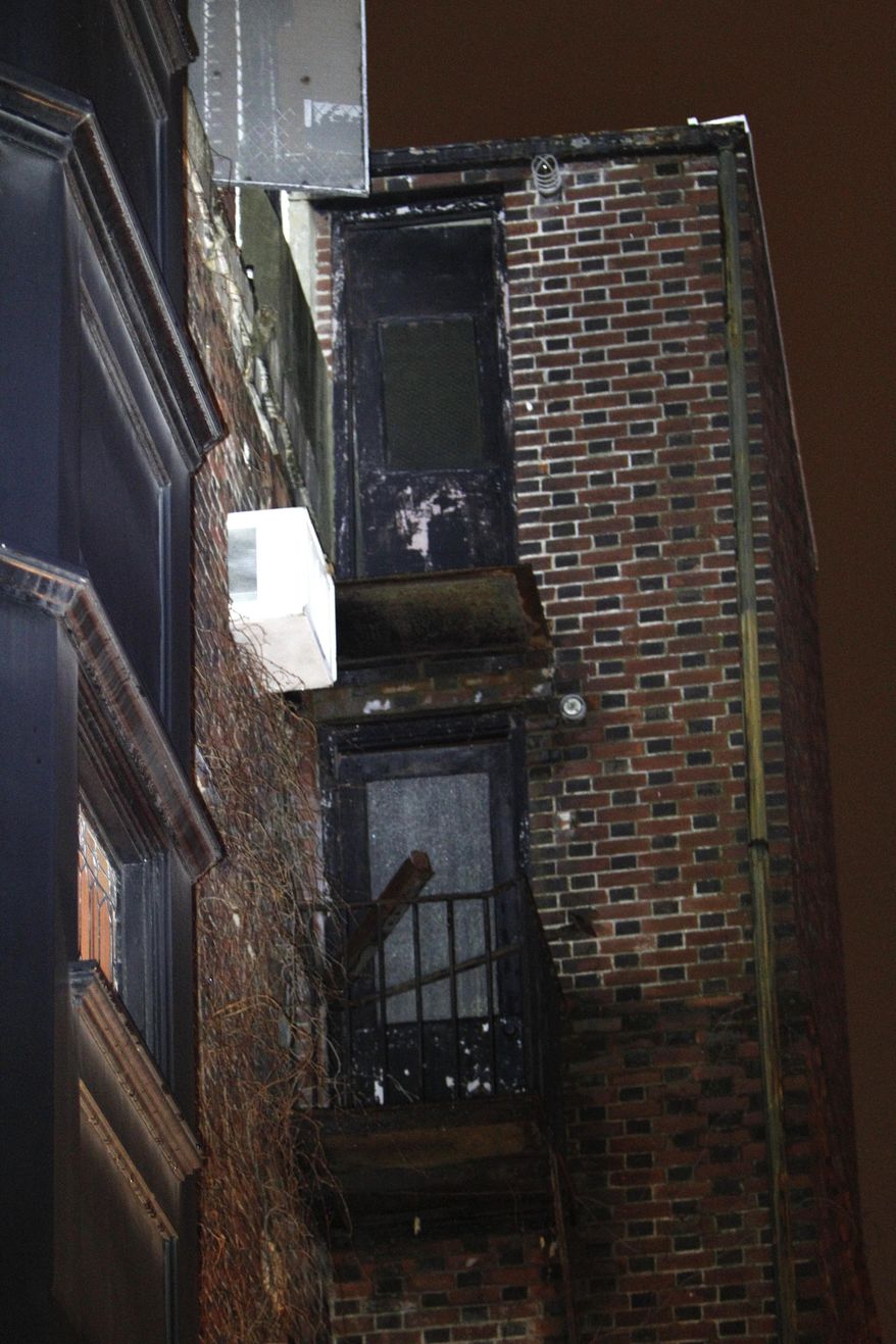 The fire escape landing that collapsed around midnight Saturday is seen in the Rittenhouse Square section of Philadelphia, Sunday, Jan. 12, 2014. Authorities say three people were injured, one critically, when a fire escape landing collapsed and fell four stories. (AP Photo/ Joseph Kaczmarek)
