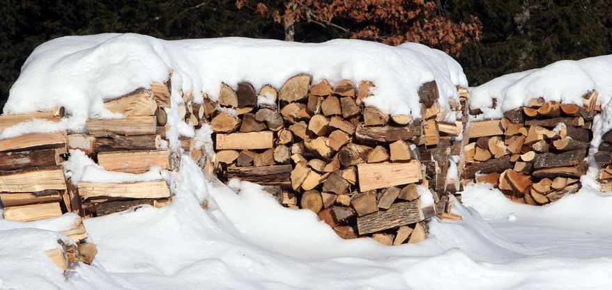 In this photo taken Wednesday Jan. 8, 2014, stacks of wood are seen at the town transfer station in Hopkinton, N.H. Like a food bank, several communities in northern New England run by church groups, social services agencies and towns, have set up wood piles for needy residents to get wood through the cold winters. (AP Photo/Jim Cole)