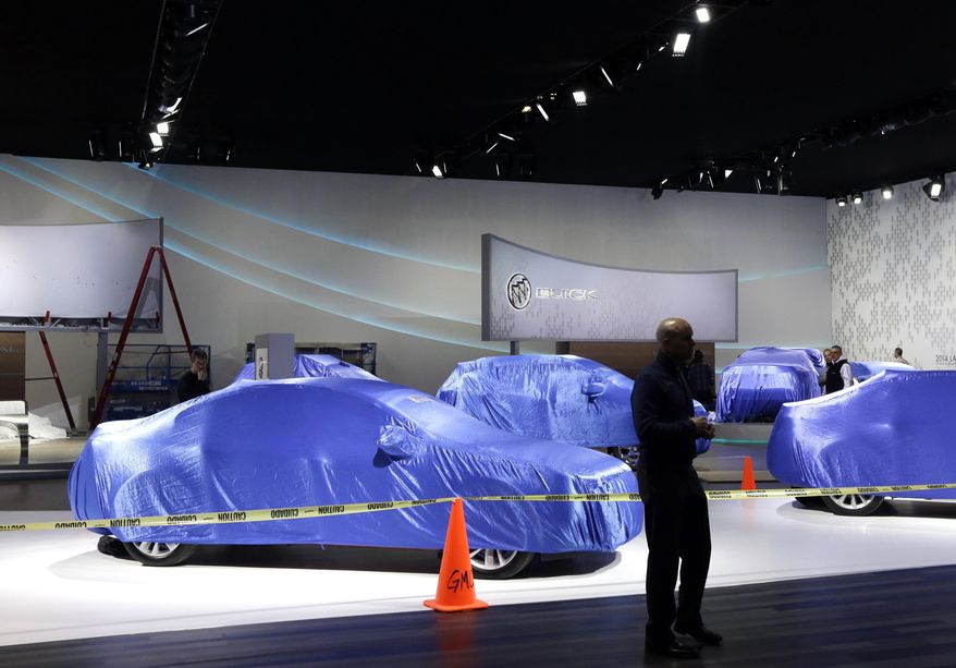 In this Thursday, Jan. 9, 2014, photo, General Motors vehicles are seen under wraps at the Cobo Center, home of the North American International Auto Show in Detroit. What the automakers introduce is crucial because sales growth is starting to slow and new models tend to capture more buyers than older ones. (AP Photo/Carlos Osorio)