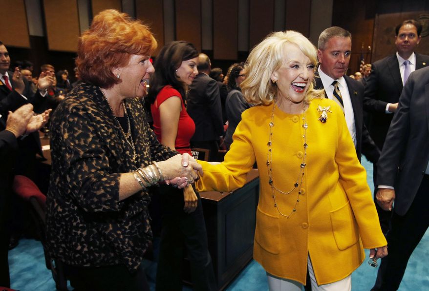 Arizona Gov. Jan Brewer, right, shakes hands with legislators and guests on the floor of the House of Representatives after giving her State of the State address at the Arizona Capitol Monday, Jan. 13, 2014, in Phoenix. The Republican governor used her annual State of the State address to focus on overhauling a troubled child welfare agency, boosting the economy and changing the way schools are funded. (AP Photo/Ross D. Franklin)