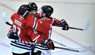 Chicago Blackhawks&#39; Jonathan Toews (19), celebrates with teammates Patrick Sharp (10), and Marian Hossa (81), after scoring a goal during the second period of an NHL hockey game against the Edmonton Oilers in Chicago, Sunday, Jan., 12, 2014. (AP Photo/Paul Beaty)
