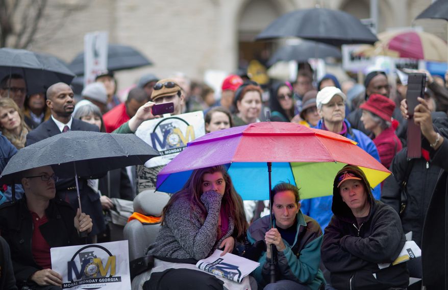 Demonstrators listen to speakers during a protest calling for an expansion to Medicaid outside the State Capitol on the first day of the legislative session, Monday, Jan. 13, 2014, in Atlanta. The protest marking the start of the "Moral Monday" movement in Georgia, aims to put pressure on Gov. Nathan Deal to expand Medicaid under the federal health care law. Deal has said the state can't afford the expansion. The effort includes various advocacy groups and the Georgia NAACP, and is modeled after a group in North Carolina. Demonstrators there were arrested weekly last year. (AP Photo/David Goldman)