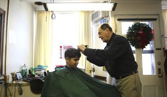 In this Jan. 3, 2014 photo, barber Steve Mihelsic cuts Michael Silas&#39; hair in his shop in Springfield, Ill. His other customers include six men he served with in the Illinois Army National Guard in the early 1960s and they&#39;ve been coming to Mihelsic for their haircuts ever since. (AP Photo/The State Journal-Register, Rich Saal)