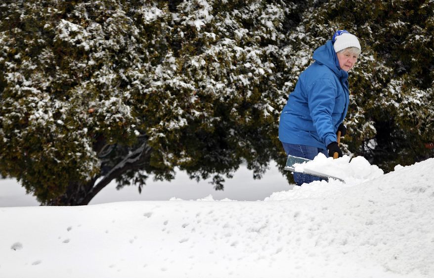 Deeanne Deer clears snow on Tuesday, Jan. 14, 2014, in Neenah, Wis. (AP Photo/The Post-Crescent, Sharon Cekada)