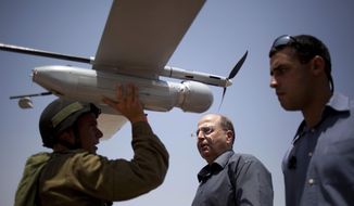 File - In this July 9, 2013 file photo, an Israeli soldier holds up a Skylark I (Rochev Shamayim) unmanned drone as part of a demonstration for Israel&#39;s Defense Minister Moshe Yaalon, center, in an urban warfare army training facility, near Zeelim, southern Israel. Israel’s defense minister was quoted Tuesday as deriding U.S. Secretary of State John Kerry’s Mideast peace efforts as naive and foolhardy, triggering an angry response from Washington and rekindling simmering tensions with Israel’s closest and most important ally. In the comments published by the Yediot Ahronot daily, Defense Minister Moshe Yaalon called Kerry “obsessive” and “messianic” and dismissed Kerry’s security plan as worthless. “The only thing that might save us is if John Kerry wins the Nobel Prize and leaves us be,” Yaalon was quoted as saying in private conversations. (AP Photo/Ariel Schalit, File)