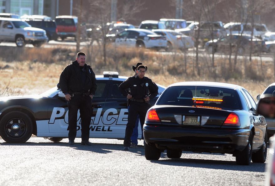 Law enforcement personnel set up a perimeter following a shooting at Berrendo Middle School in Roswell, Tuesday, Jan. 14, 2014, in Roswell, N.M. A shooter opened fire at the middle school, injuring at least two students before being taken into custody. Roswell police said the school was placed on lockdown, and the suspected shooter was arrested. (AP Photo/Roswell Daily Record, Mark Wilson)