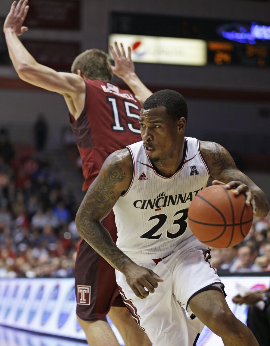 Cincinnati guard Sean Kilpatrick (23) drives around Temple forward Jimmy McDonnell (15) during the first half of an NCAA college basketball game, Tuesday, Jan. 14, 2014, in Cincinnati. (AP Photo/Al Behrman)