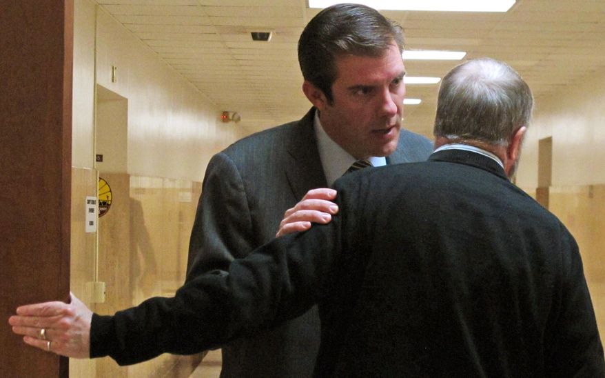 Shawnee County, Kan., District Attorney Chad Taylor, left, confers with his office's spokesman, Lee McGowan, right, after a news conference announcing felony charges against a 17-year-old boy, Wednesday, Jan. 15, 2014, at the county courthouse in Topeka, Kan. The boy is accused of planning a high school shooting. (AP Photo/John Hanna)