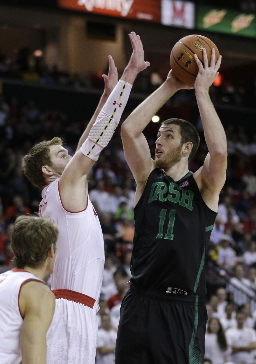 Notre Dame center Garrick Sherman (11) shoots over Maryland forward Evan Smotrycz, left, and guard/forward Jake Layman in the first half of an NCAA college basketball game in College Park, Md., Wednesday, Jan. 15, 2014. (AP Photo/Patrick Semansky)