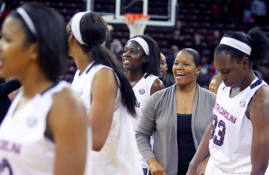 In this Nov. 8, 2013 photo, University of South Carolina assistant coach Nikki McCray, second from right, celebrates with the team after defeating Charleston Southern in Columbia, S.C. McCray says she's being treated for breast cancer. McCray said Monday, Jan. 13, 2014, she was diagnosed in November and was told by doctors her condition was treatable. McCray says she'll continue coaching through the season, if possible. (AP Photo/The State, Tracy Glantz) ALL LOCAL MEDIA OUT, (TV, ONLINE, PRINT) MBI