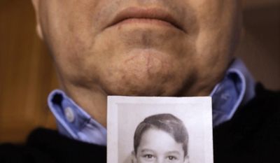 Joe Iacono, 62, who was abused in the early 1960s while he was a student at St. John Vianney Catholic School in North Lake, Ill., holds a photo of him taken in 1960 when he was 9-years-old, while talking about The Archdiocese of Chicago releasing thousands of pages documenting clergy sex abuse allegations to victims&#39; attorneys who have for years fought to hold the Catholic Church accountable for its handling of such claims, at his home Wednesday, Jan. 15, 2014, in Springfield, Ill. (AP Photo/Seth Perlman)
