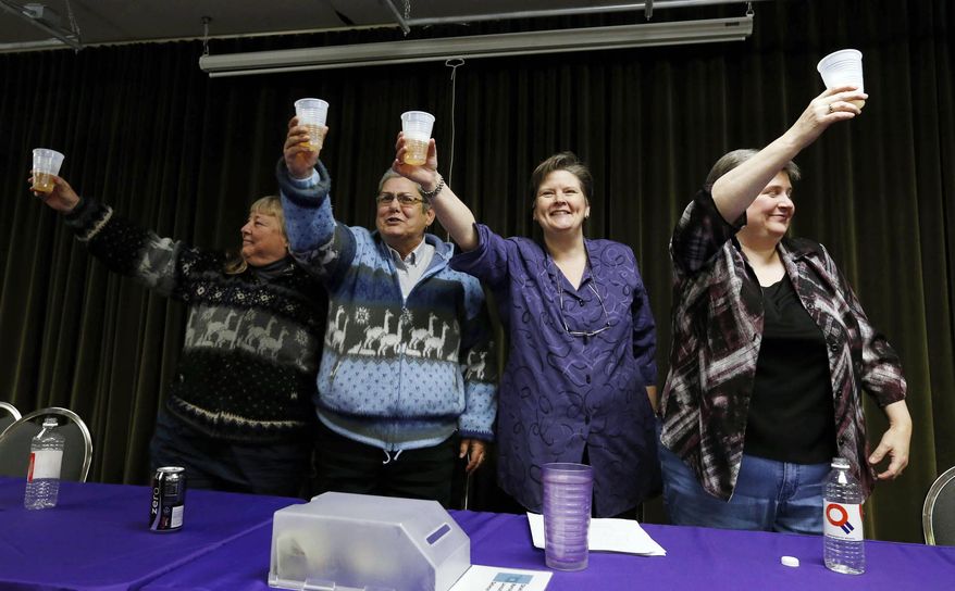 FILE - In this Tuesday, Jan. 14, 2014, file photo, Gay Phillips, left, her partner Sue Barton, along with Mary Bishop and her partner Sharon Baldwin, right, toast during a celebration at the Dennis R. Neill Equality Center, in Tulsa, Okla., after a federal judge struck down Oklahoma's gay marriage ban. But the judge headed off any rush to the altar by setting aside his order while state and local officials complete an appeal. In less than a month, two federal judges have struck down state bans on gay marriage for the same reason, concluding that they violate the Constitution’s promise of equal treatment under the law. Although that idea has been the heart of the gay marriage debate for years, the decisions in deeply conservative Oklahoma and Utah offer new momentum for litigants pressing the same argument in dozens of other cases across the country. (AP Photo/Tulsa World, James Gibbard, File)