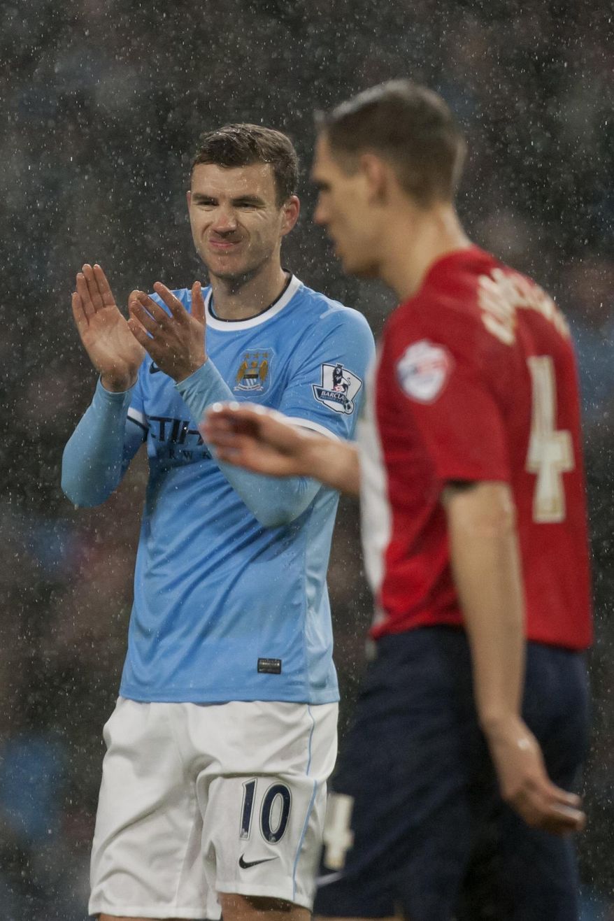 Manchester City's Manchester City's Edin Dzeko, left, reacts after a missed opportunity during his team's English FA Cup third round replay soccer match against Blackburn at The City of Manchester Stadium, Manchester, England, Wednesday, Jan. 15, 2014. (AP Photo/Jon Super)