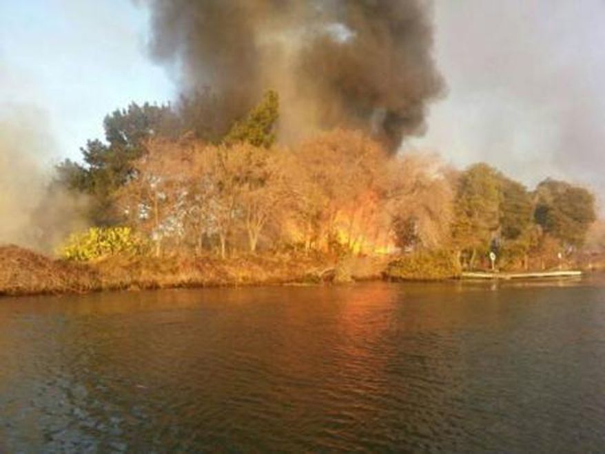 In this image provided by the U.S. Coast Guard shows a brush fire on Kimball Island in the San Joaquin River, Sacramento, Calif., Tuesday, Jan. 14, 2014. The Coast Guard Station Rio Vista evacuated four people from the island Tuesday after arriving on the scene. Tuesday's wildfires struck an unusually arid and windy Northern California, where a fire on the small Kimball Island between San Francisco and Sacramento engulfed at least one of the island's 20 buildings and was threatening others, Solano County fire dispatcher Robyn Rains said. (AP Photo/Coast Guard Station Rio Vista, Petty Officer Loumania Stewart)