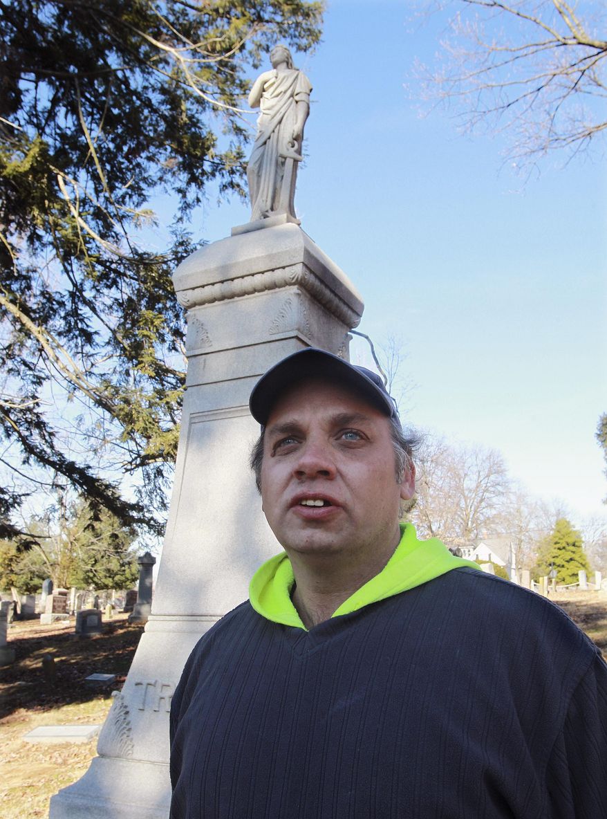 ADVANCE FOR USE SUNDAY, JAN. 19 AND THEREAFTER - In this Dec. 24, 2014 photo, Woodlawn Cemetery sexton Edward Ricks poses in front of an ornate grave marker at the Edwardsville, Ill., cemetery that is still recovering from a summer storm. The statue on the top had been knocked off in the storm. (AP Photo/Belleville News-Democrat, Tim Vizer)