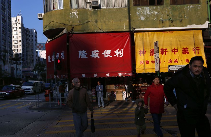 Pedestrians cross a street at an old district area in Hong Kong Wednesday Jan. 15, 2014. Hong Kong's Chief Executive Leung Chun-ying delivered his policy address on Wednesday in which he pledged to tackle Hong Kong's housing shortage as well as increase assistance to low-income families. (AP Photo/Kin Cheung)
