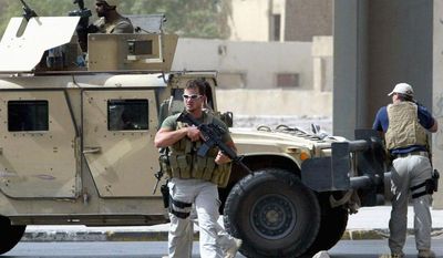 AGENCE FRANCE-PRESSE/GETTY IMAGES
Contractors of the U.S. security firm Blackwater secure the site of a roadside attack near the Iranian Embassy in Baghdad in 2005. The firm, whose guards were accused of fatally shooting 17 Iraqi civilians in 2007, left Baghdad on Thursday.
