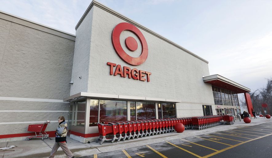In this Dec. 19, 2013, file photo, a passer-by walks near an entrance to a Target retail store in Watertown, Mass. (AP Photo/Steven Senne, File) **FILE**