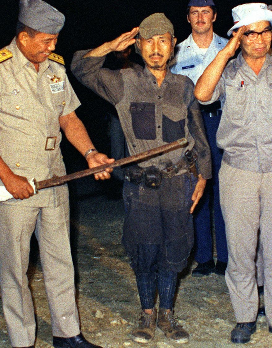 FILE - In this March, 1974 photo, Hiroo Onoda, center, salutes after handing over his military sword on Lubang Island, Philippines, when he comes out of hiding in the jungle. Onoda, the last Japanese imperial soldier to emerge from hiding and surrender after World War II, has died. He was 91. Onoda died Thursday, Jan. 16, 2014 at a Tokyo hospital. (AP Photo/Kyodo News) JAPAN OUT, CREDIT MANDATORY