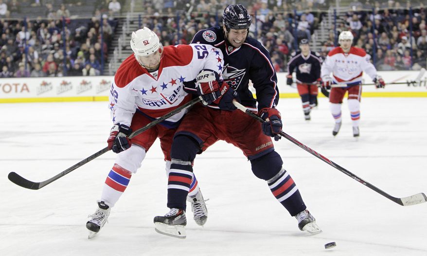 Washington Capitals&#39; Mike Green, left, and Columbus Blue Jackets&#39; RJ Umberger chase a loose puck during the second period of an NHL hockey game on Friday, Jan. 17, 2014, in Columbus, Ohio. (AP Photo/Jay LaPrete)
