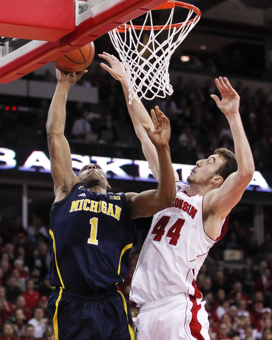 Michigan's Glenn Robinson III (1) shoots against Wisconsin's Frank Kaminsky during the first half of an NCAA college basketball game Saturday, Jan. 18, 2014, in Madison, Wis. (AP Photo/Andy Manis)