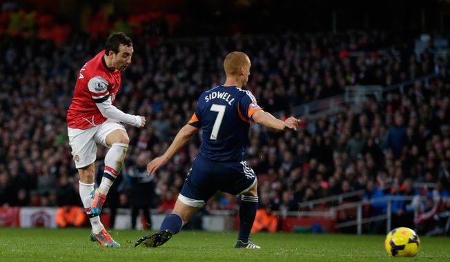 Arsenal's Santi Cazorla, left, scores his side's second goal past Fulham's Steve Sidwell during the English Premier League soccer match between Arsenal and Fulham at the Emirates Stadium in London, Saturday, Jan. 18, 2014.  (AP Photo/Matt Dunham)