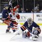 New York Rangers goalie Henrik Lundqvist (30), of Sweden, stops a shot on the goal as Detroit Red Wings&#39; Mikael Samuelsson and Michael Del Zotto (4) fight for position during the first period of an NHL hockey game, Thursday, Jan. 16, 2014, in New York. (AP Photo/Frank Franklin II)