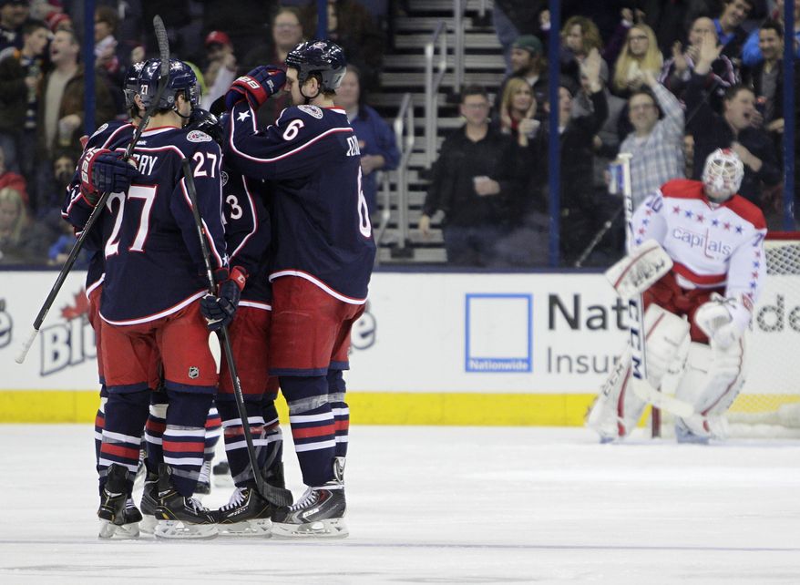 Columbus Blue Jackets players celebrate a goal against Washington Capitals' Braden Holtby, right, during the third period of an NHL hockey game on Friday, Jan. 17, 2014, in Columbus, Ohio. The Blue Jackets won 5-1. (AP Photo/Jay LaPrete)