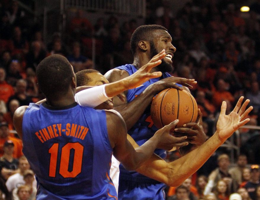 Florida center Patric Young, right, fights for possession with Auburn center A. Dixon-Tatum, center, and Florida forward D. Finney-Smith (10) during second-half action of an NCAA college basketball game in Auburn, Ala., Saturday, Jan. 18, 2014. (AP Photo/Jay Sailors)